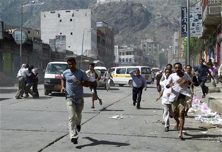 متظاهرون يهربون بعد ان فتحت قوات الأمن اليمنية النار عليهم في تع