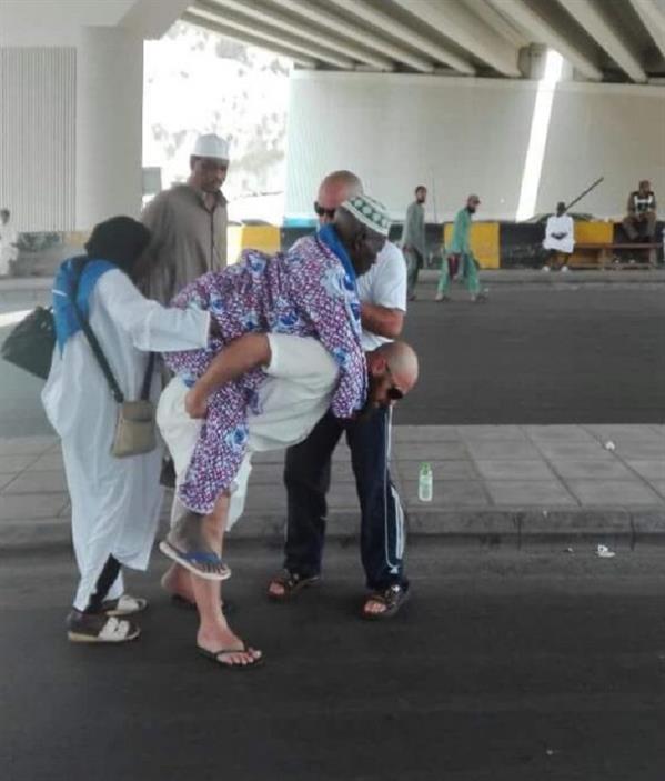 شاب يحمل رجلاً مسناً على ظهره لمساعدته في الوصول للمسجد الحرام