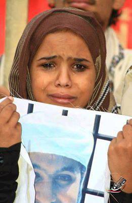 طفلة يمنية تحمل صورة والدها المعتقل بغوانتنامو