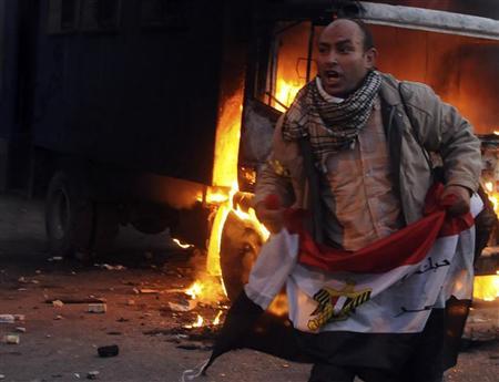 محتج يحمل علم مصر خلال اشتباكات مع الشرطة في ميدان التحرير بالقا