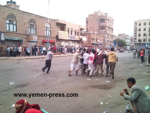 شباب الثورة ينقلون أحد المصابين برصاص قناصة وسط عمليات قنص