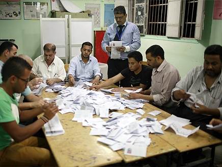 مسؤولون في اللجنة الانتخابية يفرزون الأصوات في مركز اقتراع بالقا